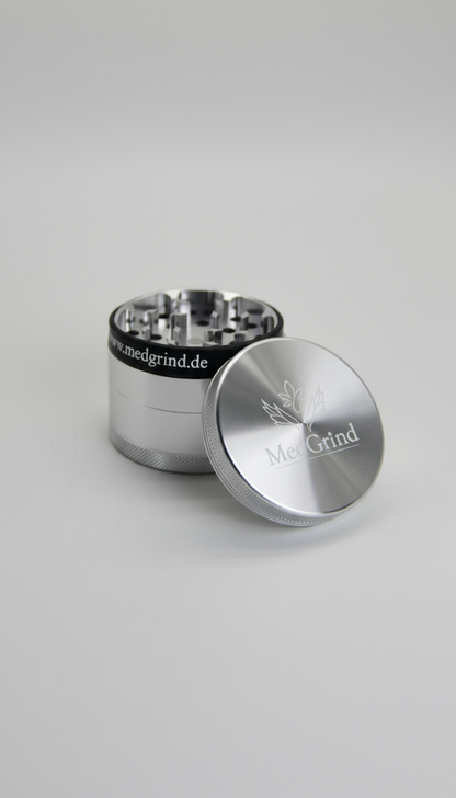 Geöffneter Edelstahl Grinder von MedGrind mit schwarzem Silikon-Schutzring und abgenommenem Deckel