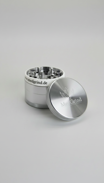 Geöffneter Edelstahl Grinder von MedGrind mit weißem Silikon-Schutzring und abgenommenem Deckel
